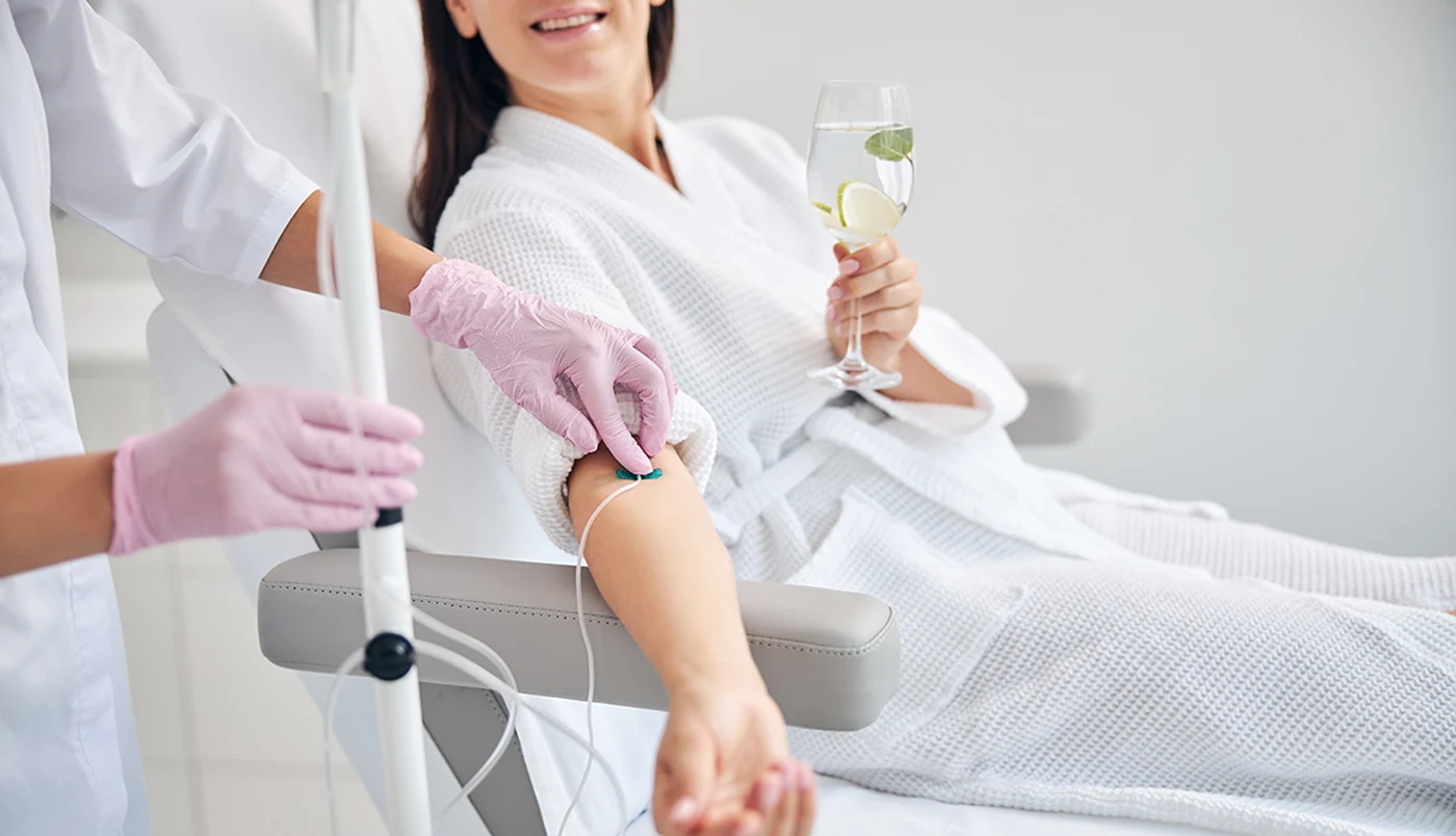 Patient receiving an IV drip infusion in a treatment chair at Aeconic Aesthetic Clinic, Canggu, Bali